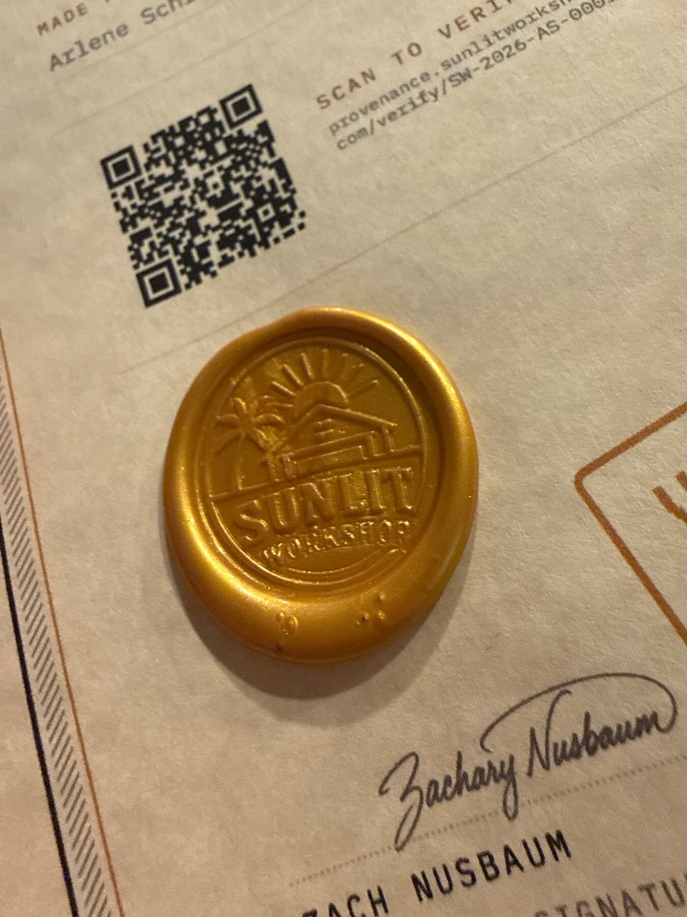 Sunlit Workshop wax seal beside the QR code and signature on a certificate